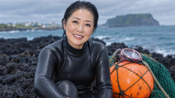Photo Humanizer sample: Edit: a Jeju sea diver's waxy AI sheen changed to real pores, creases and overcast light.