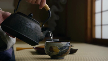 Add Audio sample: Audio added: a kettle pours into a ceramic cup on tatami, now scored with a calm ambient bed.