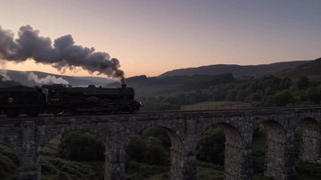 Gemini Omni Flash 1.1 sample: A train crossing a stone viaduct at dusk